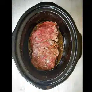 Flank steak cooking in crock pot with marinade
